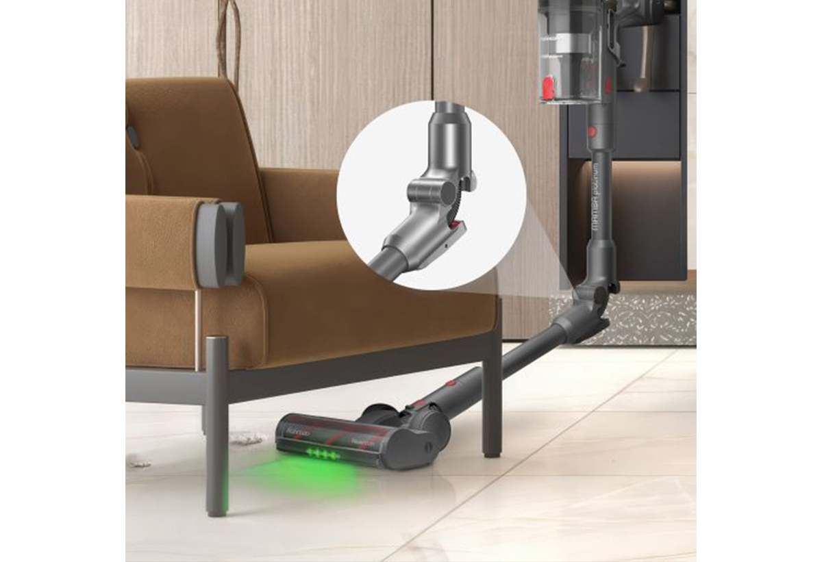 ΕΜφανίζεται η σκούπα να καθαρίζει κάτω από μια πολυθρόνα χάρη στον εύκαμπτο σωλήνα της.